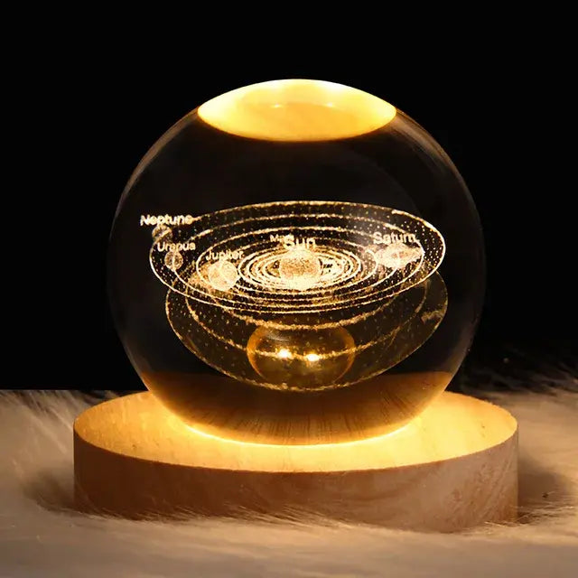 Glass sphere with solar system model on a wooden base against a dark background