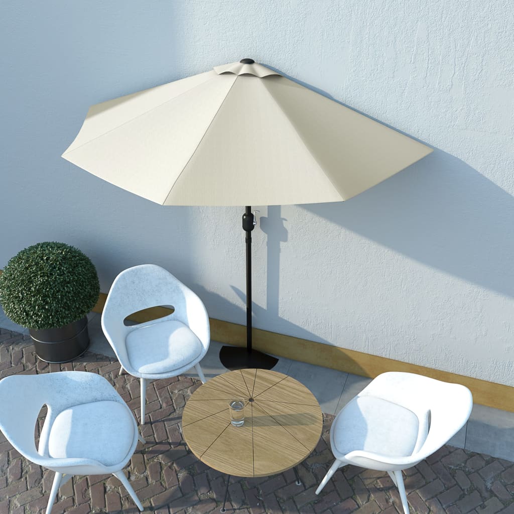 Outdoor patio set with beige umbrella, white chairs, and round wooden table against a light blue wall.