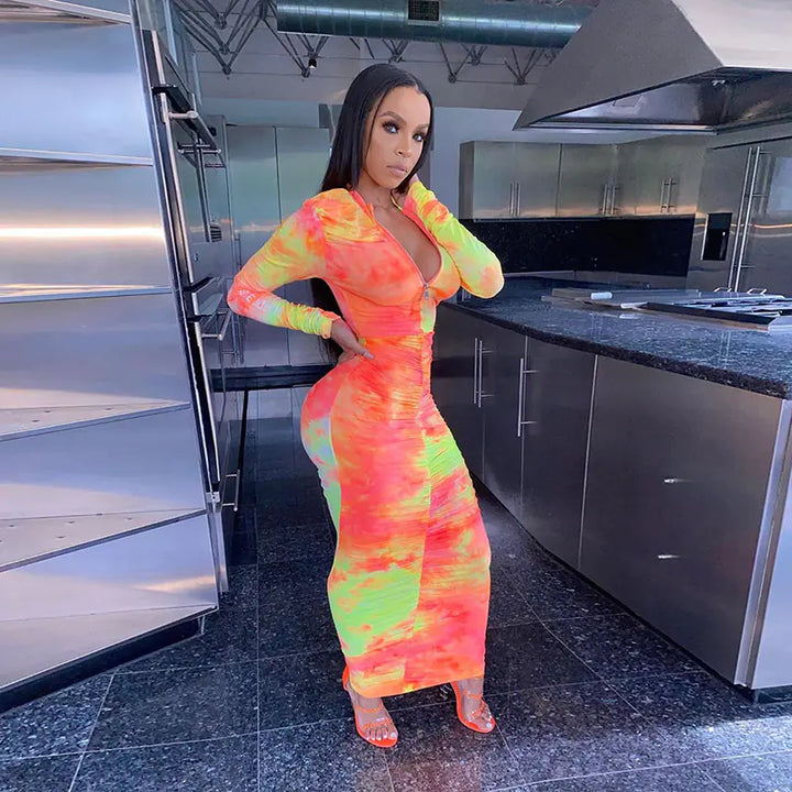 Woman in a colorful dress standing in a modern kitchen.
