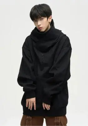 Person wearing a black oversized hoodie on a plain background