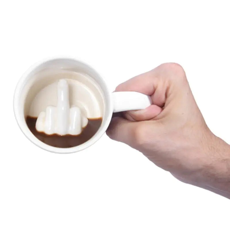 Hand holding a mug with a white foam top on a white background