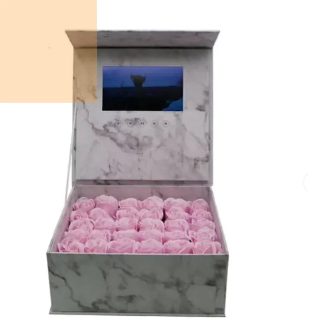 Marble-patterned box with pink roses and a digital screen displaying a mountain scene.