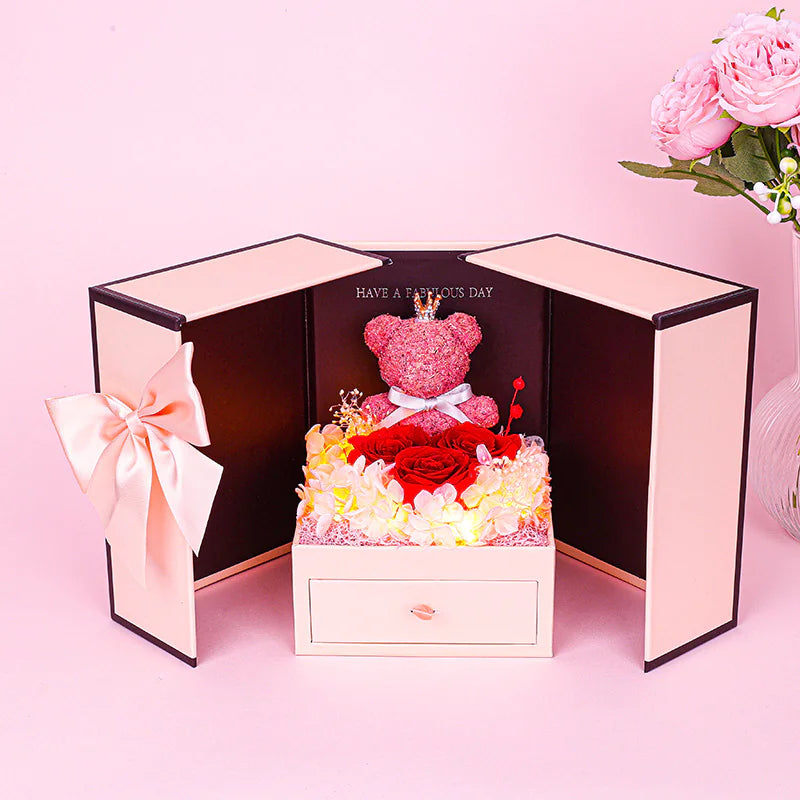 Decorative box with a teddy bear and flowers on a pink background