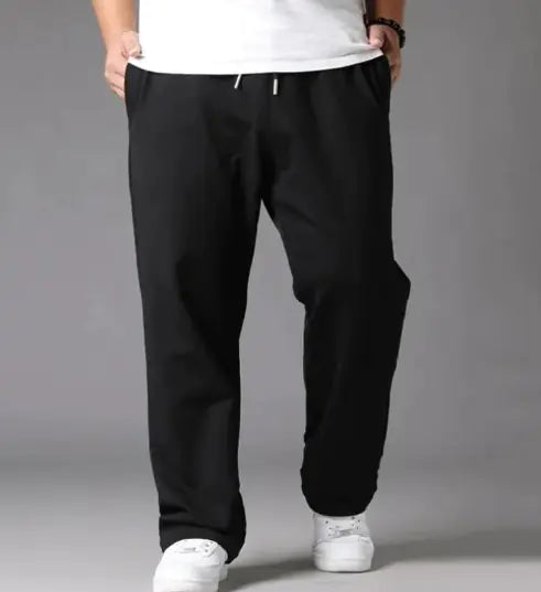 Person wearing black pants and white shoes on a gray background