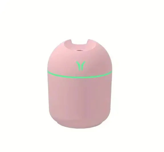Pink humidifier with a green light on a white background