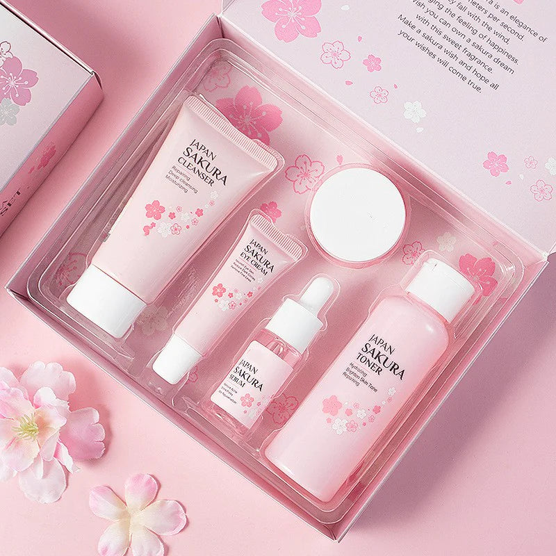 Cosmetic set with Sakura Cleanser, Emulsion, and Toner in a decorative box on a pink background with flowers.