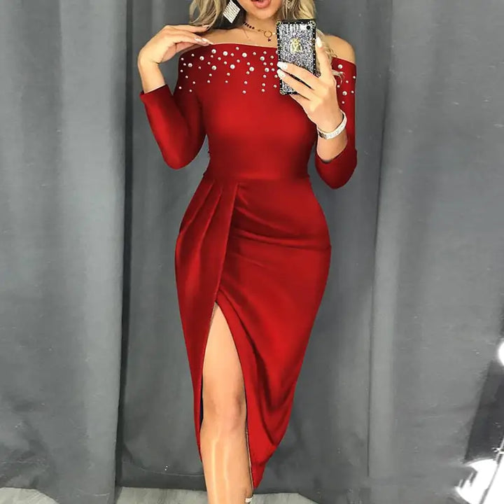 Red off-shoulder dress with embellishments against a gray curtain background