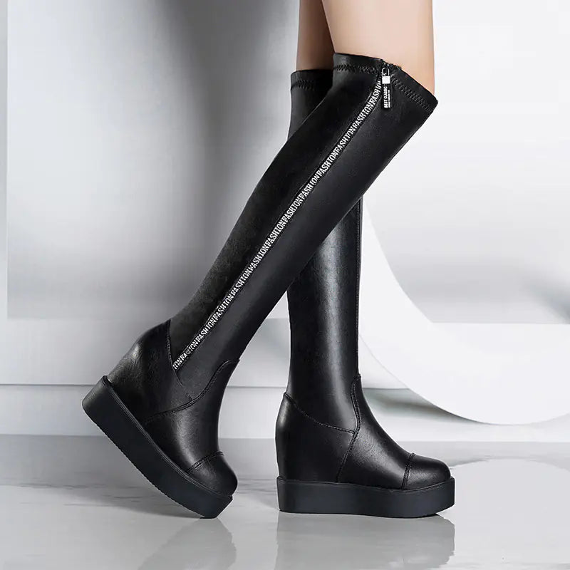 Black knee-high boots with platform sole on a white background