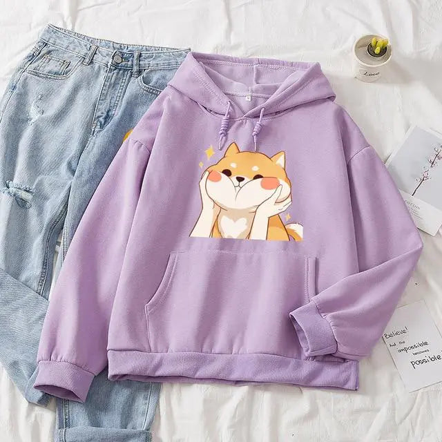 Purple hoodie with a dog graphic on a white surface with jeans and a card.