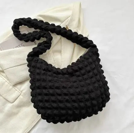 Black textured handbag on a white background