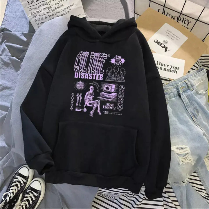Black hoodie with graphic design on a bed with jeans and sneakers